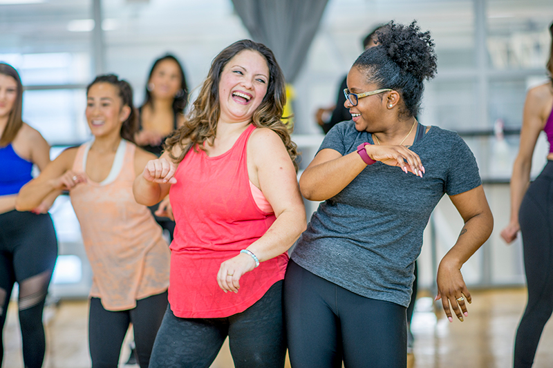 group of happy women dancing in a fitness class